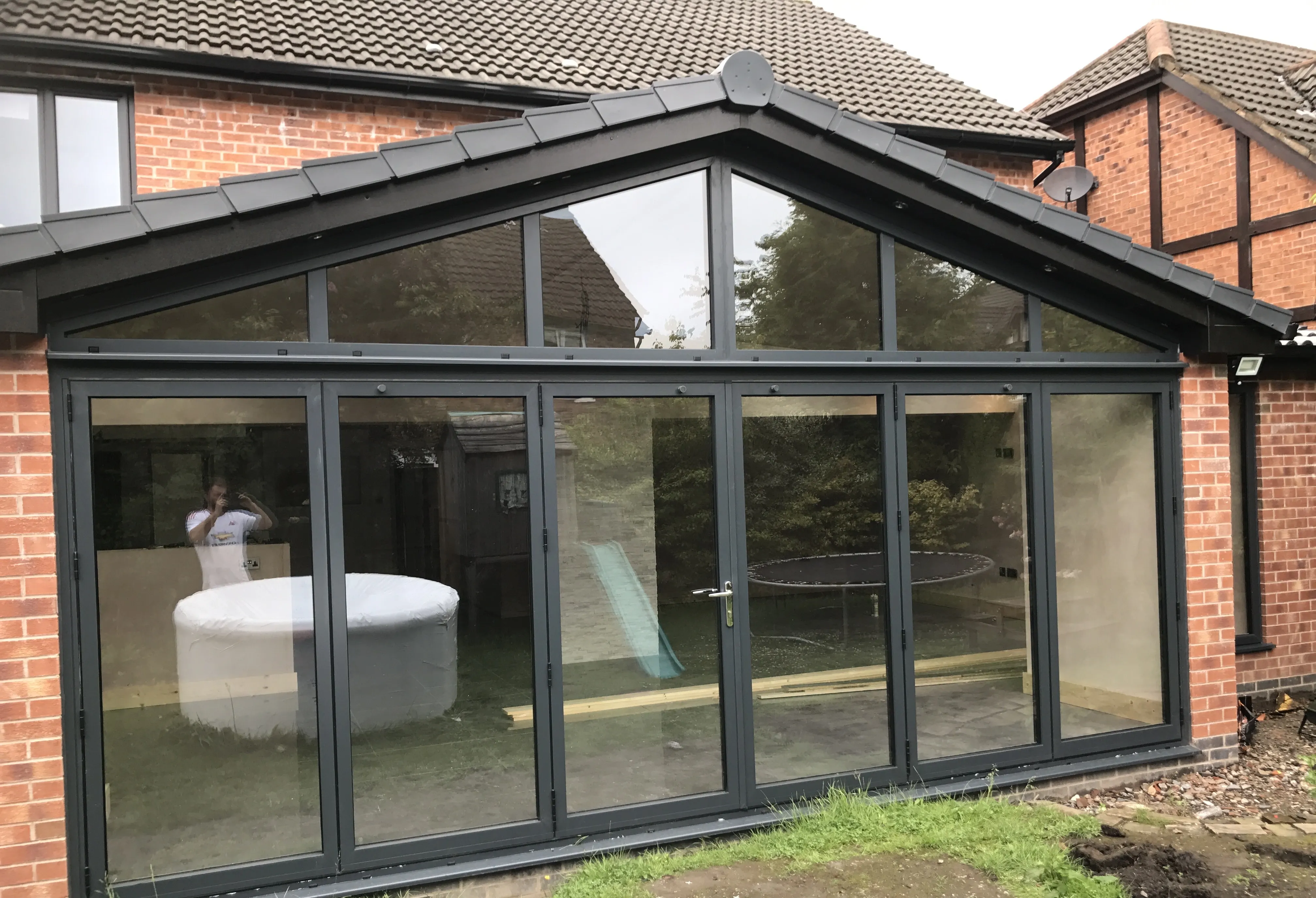 Pitched-roof rear extension with full-width bifold glazing on a brick house